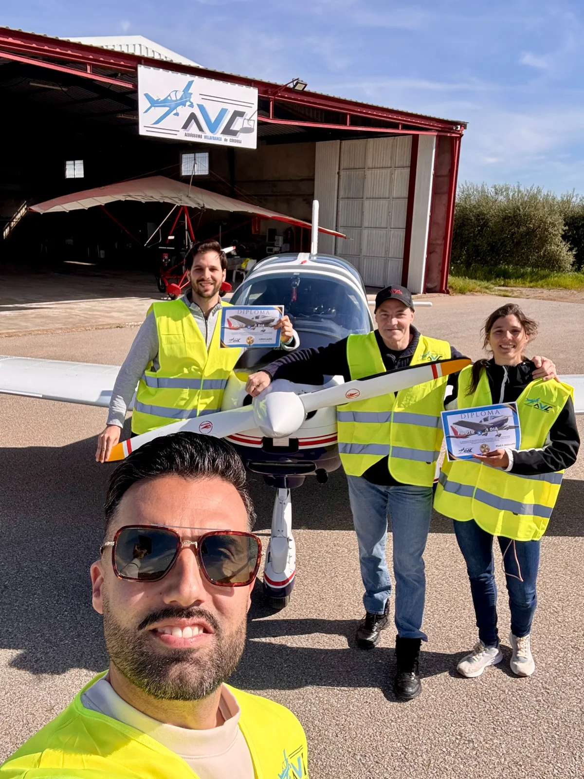 Participantes de una experiencia aérea mostrando sus diplomas junto a la avioneta Tecnam del Aeródromo Villafranca
