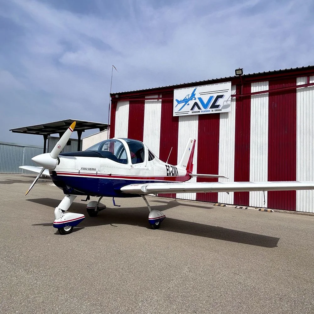 Avioneta Tecnam P2002 Sierra frente al hangar del aeródromo